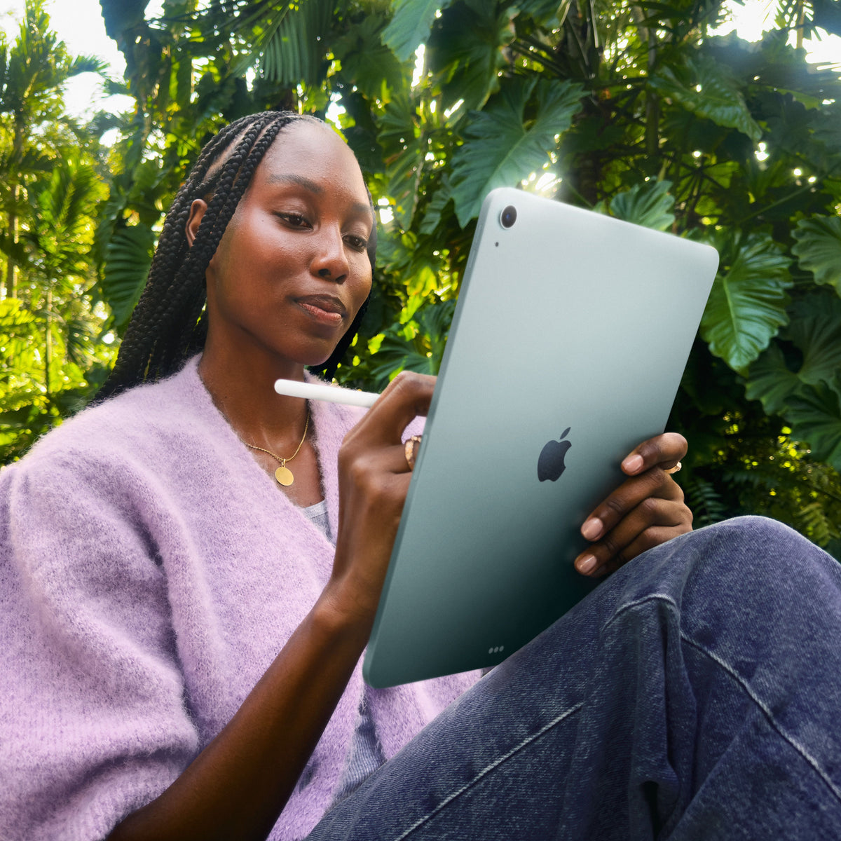 Woman using an Apple Pencil for writing on the 13-inch iPad Air Wi-Fi 128GB Purple M4 at Tradeline.
